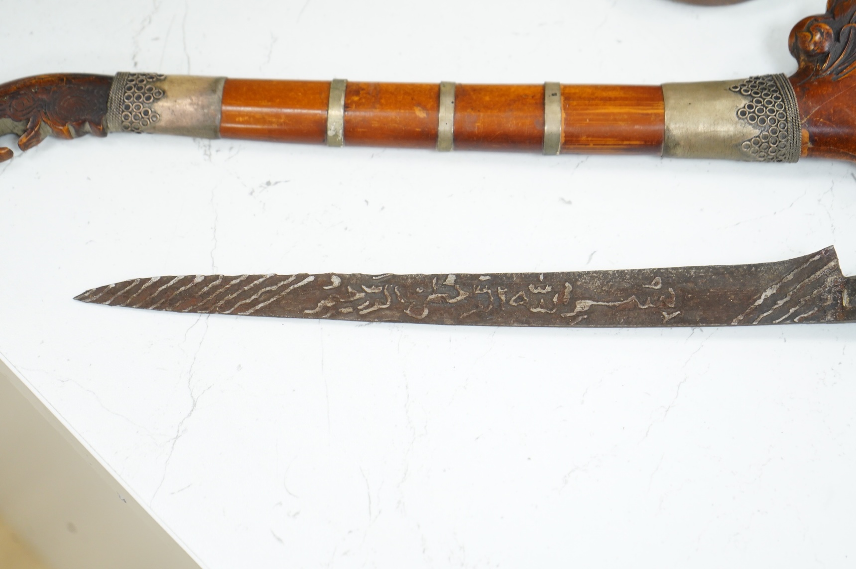 A Javanese dagger kris with straight pamor blade, wooden hilt carved as raksha, in its wooden sheath, together with a decorative dagger bade-bade, with etched blade